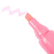 A close-up of a Universal chisel tip highlighter with a pink and white barrel.