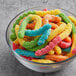 A bowl of colorful Albanese Large Sour Neon Gummi Worms.