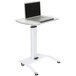 A white Luxor pneumatic adjustable height lectern with a laptop on it.
