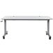 A white rectangular Luxor adjustable height nesting table with wheels.