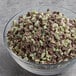 A bowl of Andes Mint Topping with crushed green and brown candies on a table.