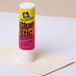 A white Avery glue stick on a table.