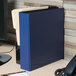 An Avery blue economy binder on a desk.
