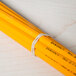 A close up of a beige Universal rubber band wrapped around pencils.