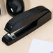 A black Universal Executive stapler on a desk.