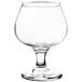 A clear glass snifter with a small base and a stem.