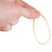 A person holding a thin beige Universal rubber band.