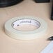 A Universal roll of general purpose masking tape on a desk.
