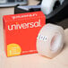 A roll of Universal clear invisible tape next to a box.
