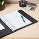 An Avery black economy non-view binder with a pen and calculator on a desk.