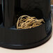 A black Universal rubber band container on a hotel buffet counter filled with beige rubber bands.