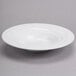 A Tuxton TuxTrendz bright white china pasta bowl on a gray surface.