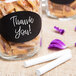 A jar of white sticks with a thank you note inside filled with candy.