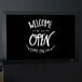 A black MasterVision chalk board with white text that says welcome open.
