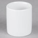 A Tuxton bright white ceramic sugar packet holder on a grey surface.