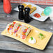 A Tuxton Saffron stackable plate with tacos and drinks on a table.