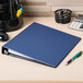 An Avery blue binder with 1" slant rings on a desk.