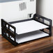 A black Universal side load stackable desk tray with papers in it.