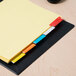 A stack of paper with Avery Big Tab multi-color dividers on top.