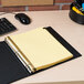 A binder with Avery 11350 Pre-Printed Black Leather A-Z Dividers on a desk with yellow papers.