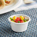A small white EcoChoice Bagasse portion cup with vegetables in it.