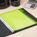 A green Avery binder with green paper and a calculator.