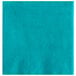 A teal beverage napkin with a white spot.