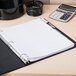A binder with Avery Big Tab dividers holding papers on a table with a calculator.