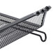 A close-up of a black metal mesh stackable tray with a handle.