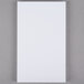 A white rectangular Universal scratch pad on a gray surface.