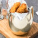 An American Metalcraft mirrored gold Moscow Mule mug filled with fried chicken nuggets.