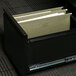 A black file drawer with a drawer open filled with UNV14151 legal size hanging file folders.