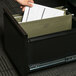 A person putting a UNV14151 legal size box bottom hanging file folder in a drawer.