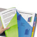 A hand holding a green and blue folder with Avery 2-pocket plastic insertable tab dividers.