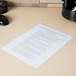A clear Universal letter size poly file jacket holding a paper on a table.