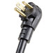A close-up of a black power cord plug with two gold prongs.