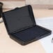 A black rectangular Avery foam stamp pad with a black cover on a table.
