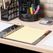 A Universal multicolored 5-tab divider set in a binder on a desk.