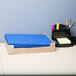 A white desk with a stack of light blue Universal embossed paper pocket folders.