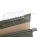 A close-up of a green UNV24115 reinforced hanging file folder with plastic clips.