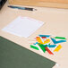 A group of colorful Avery plastic index tabs with printable inserts next to a pen on white paper.