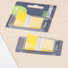 A package of two yellow Universal page flags sitting on a white surface.