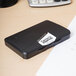 A black rectangular Avery Carter's pre-inked stamp pad on a desk with a white label.