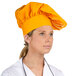 A woman wearing a gold Intedge chef's hat.