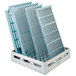 A white MetroMax Q shelving unit with blue plastic crates on white plastic grids.