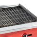 An Avantco cast iron grill top on a red charbroiler.