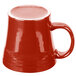 A white china mug with a red exterior and white interior and handle.