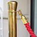 A gold pole with a red rope attached to it.