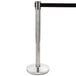 A silver Lancaster Table & Seating crowd control stanchion pole with a black top and silver retractable belt.