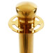 A gold Lancaster Table & Seating rope-style crowd control stanchion with a metal cap.